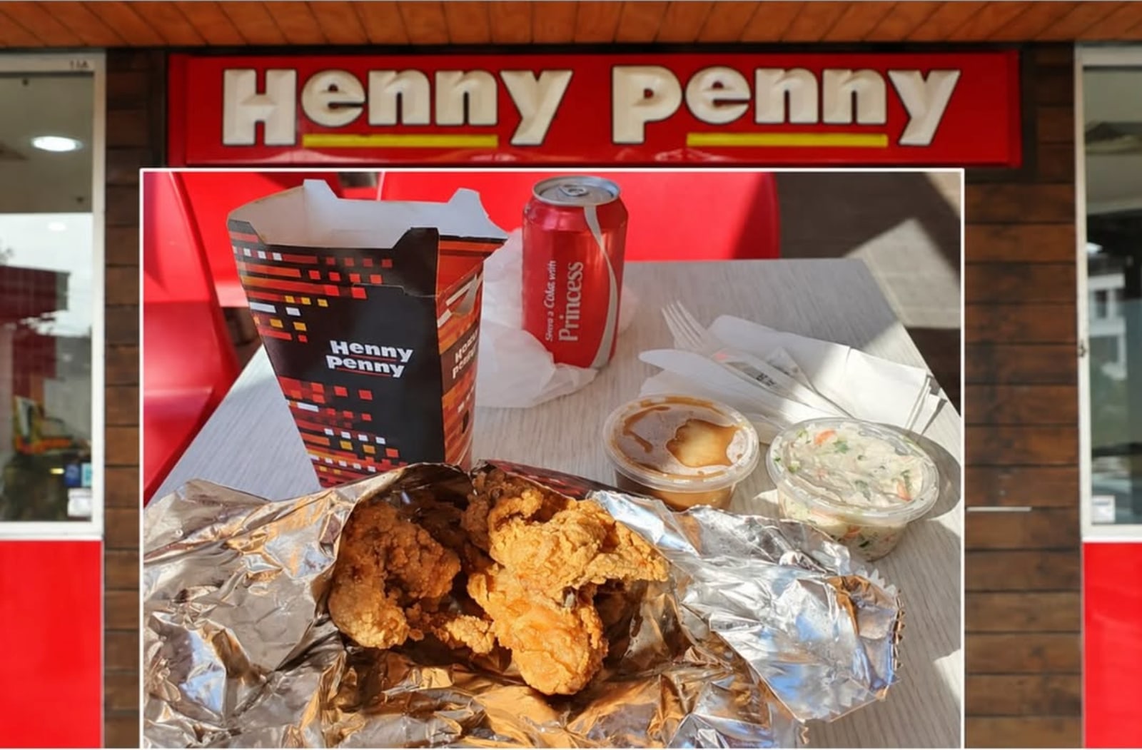 A Henny Penny chicken feed spread out on foil beneath the shopfront sign.