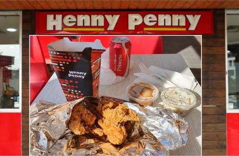 A Henny Penny chicken feed spread out on foil beneath the shopfront sign.