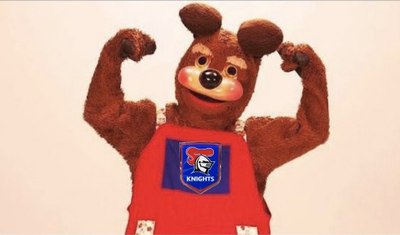 A bear mascot in red overalls flexing both arms.