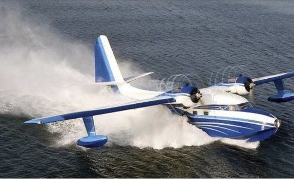 A blue and white seaplane skimming across the water.